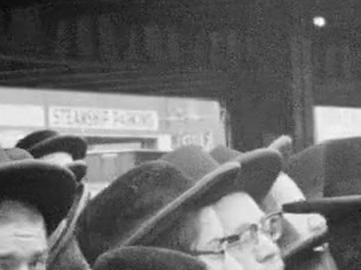 Closer frame at 0:03 in the 1965 film, with the Steamship Parking sign behind the crowd at Pier 90